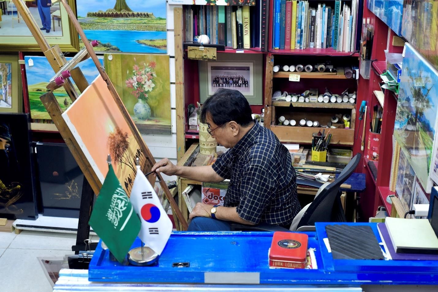 كيم سنغباي في أثناء رسمه داخل المعرض. تصوير أكبر حسين