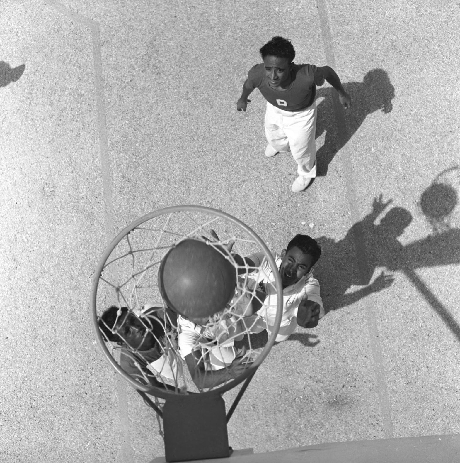 الظهران، 15 أغسطس 1953محمد بن عبد الله يُسجل سلة مثالية في الربع الأخير من المباراة. بإذن من أرشيف أرامكو. 