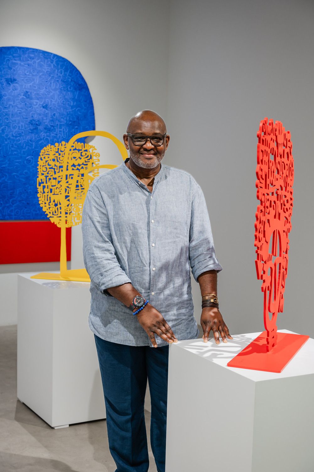 Viktor Ekpuk alongside his artworks at the INTERwoven TEXTures exhibition in Efie Gallery. Courtesy of the Dubai Culture and Arts Authority.