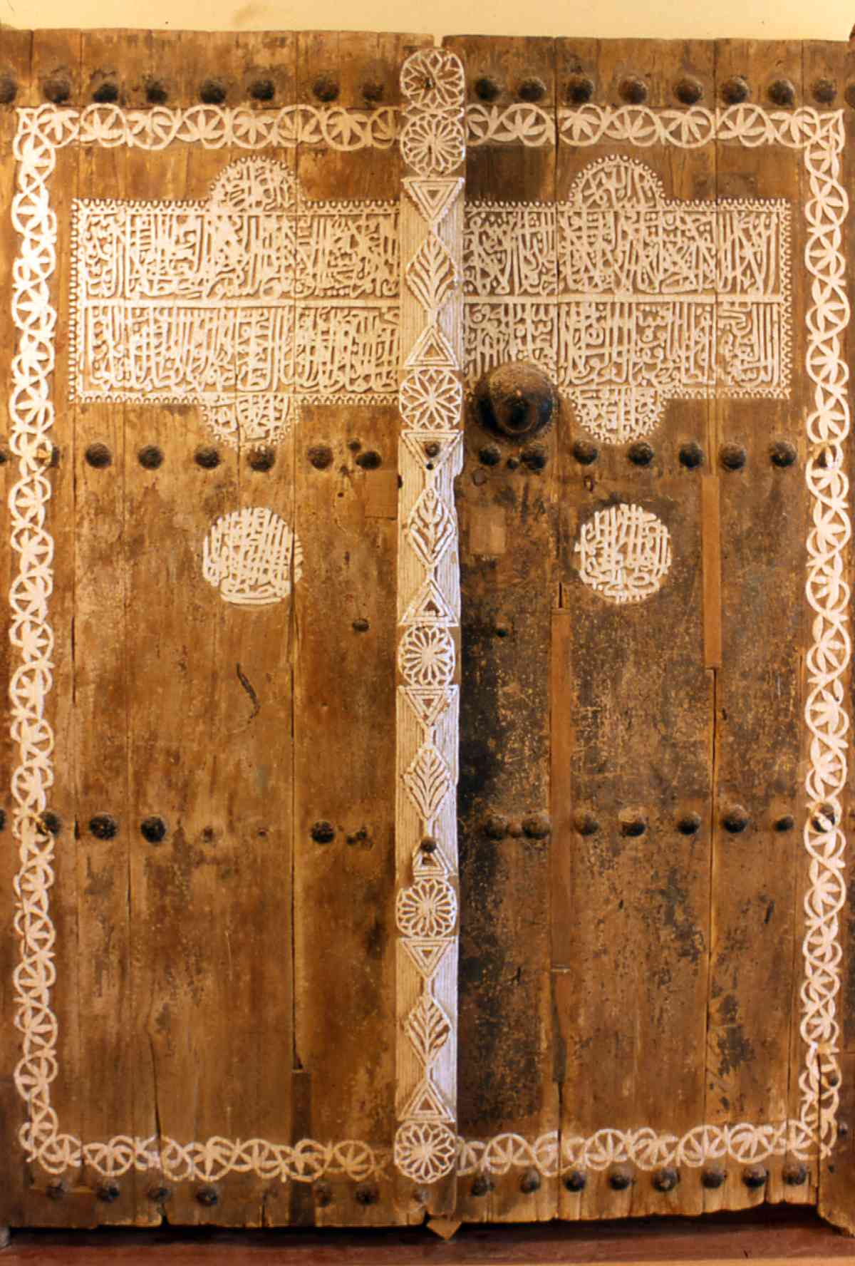 باب مسماري مُزين بالنقوش والآيات القرآنية في القطيف. بإذن من د. سعيد الوايل.&nbsp;